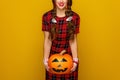 Happy woman on yellow background holding jack-o-lantern pumpkin Royalty Free Stock Photo
