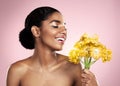 Happy woman, yellow flowers and natural skincare in studio, pink background and eco friendly makeup cosmetics. African Royalty Free Stock Photo