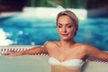 Happy womani sitting in jacuzzi at poolside Royalty Free Stock Photo