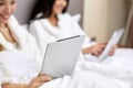 Happy women in bathrobes with tablet pc at hotel Royalty Free Stock Photo