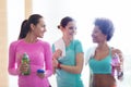 Happy women with bottles of water in gym Royalty Free Stock Photo