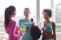 Happy women with bottles of water in gym Royalty Free Stock Photo