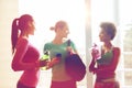 Happy women with bottles of water in gym Royalty Free Stock Photo