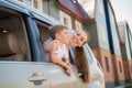 Happy woman and child look out of a car window. Cheerful boy with his mother are sitting in the back seat of the car and Royalty Free Stock Photo