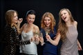 Happy women clinking champagne glasses over black