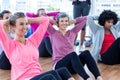 Happy women doing sit ups on hardwood floor Royalty Free Stock Photo