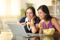Happy women eating potato chips and watching video Royalty Free Stock Photo