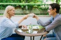 Happy women friends clinking coffee cups in open air cafe enjoying summer day Royalty Free Stock Photo