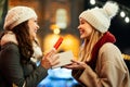 Happy women friends exchanging christmas present. Happiness people friend shopping xmas concept