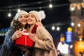 Happy women friends exchanging christmas present. Happiness people friend shopping xmas concept