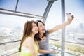 Happy women girlfriends taking a selfie in ferris wheel