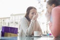 Happy women gossiping at outdoor cafe