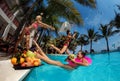 Happy women jumping in pool party at sunset - Young  people having fun in tropical vacation - Holiday, youth lifestyle Royalty Free Stock Photo