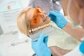 Cute smiling female during the professional dental treatment in medicine center Royalty Free Stock Photo