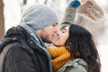 A happy young man and woman kissing in winter enjoying life and