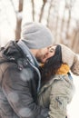 A happy young man and woman kissing in winter enjoying life and