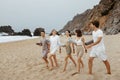 Happy women and men preparing for fresh workout on the beach at coastline, walking, enjoying summer ocean training Royalty Free Stock Photo