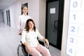 Cheerful nurse helping patient on wheelchair stock photo