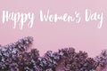Happy women`s day floral greeting card. Handwritten greetings on lilac flowers purple border on pink paper. International women`
