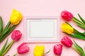 Happy Women`s Day, Mother`s Day greeting card concept. Pink tulips flowers and photo frame on pink background, copy space for yo Royalty Free Stock Photo