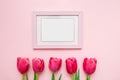 Happy Women`s Day, Mother`s Day greeting card concept. Pink tulips flowers and photo frame on pink background, copy space for yo Royalty Free Stock Photo