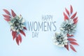 Happy Women`s Day Pastel Blue Colored Background. Flat lay floral greeting card with beautiful silk flowers.