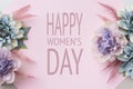 Happy Women`s Day Pastel Pink Colored Background. Flat lay floral greeting card with beautiful silk flowers.