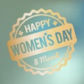 Happy Women`s Day rubber stamp gold on a blue bokeh fog background. Royalty Free Stock Photo