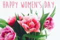 Happy Women`s Day text sign on beautiful pink and purple double peony tulips in light. International women`s day. Stylish floral