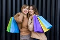 Happy women with shopping bags in fur coats posing on city street Royalty Free Stock Photo