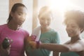 Happy women showing time on wrist watch in gym Royalty Free Stock Photo