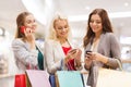 Happy women with smartphones and shopping bags Royalty Free Stock Photo