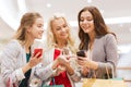 Happy women with smartphones and shopping bags Royalty Free Stock Photo