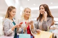 Happy women with smartphones and shopping bags