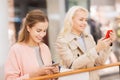 Happy women with smartphones and shopping bags Royalty Free Stock Photo