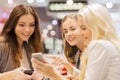 Happy women with smartphones and tablet pc in mall