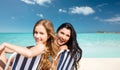 Happy women sunbathing in chairs on summer beach Royalty Free Stock Photo