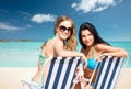 Happy women sunbathing in chairs on summer beach Royalty Free Stock Photo