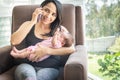 Happy woman talking on the cell phone with her baby in her arms Royalty Free Stock Photo