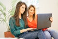 Happy women using computer notebook in the living room at home - Young people surfing on laptop watching video