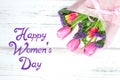 Happy womens day with bouquet of tulips in background