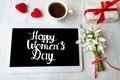 Happy womens day calligraphy note on a tablet