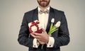 Happy womens day. Elegant man cropped view hold present box and tulips. Spring flowers. Floral shop. Florists. Gift Royalty Free Stock Photo