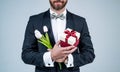 Happy womens day. Elegant man cropped view hold present box and tulips. Spring flowers. Floral shop. Florists. Gift Royalty Free Stock Photo