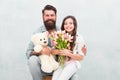 Happy womens day. Happy family celebrate womens day. Bearded man and little child hold flowers and toy. Father and small
