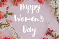 Happy womens day greeting card. Happy womens day text and stylish spring flowers composition on pink background flat lay.