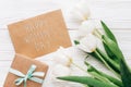 happy womens day text sign on stylish craft present with greeting card and tulips on white wooden rustic background. flat lay wit Royalty Free Stock Photo