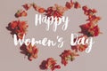 Happy womens day text and stylish heart shape with red flowers on pink background flat lay. Floral Greeting card. Handwritten Royalty Free Stock Photo