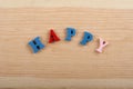 HAPPY word on wooden background composed from colorful abc alphabet block wooden letters, copy space for ad text. Learning english Royalty Free Stock Photo