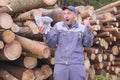 Happy Worker logger or carpenter have big money near a pile of logs, sawn wood. Concept of successful business in